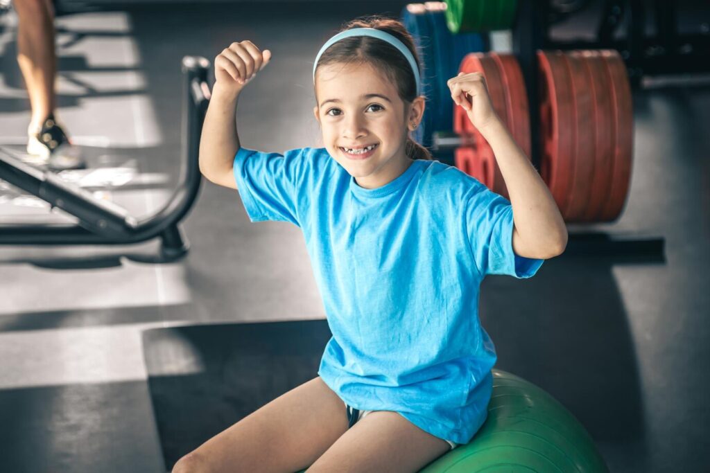 charming little girl is shows her biceps